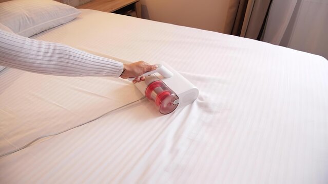Person using a pillow on bed in bedroom setting