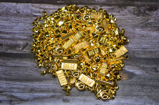 simulated golden bars and small ingots made of plastic rather than genuine precious metal, sold in large sets for decorative purposes, DIY crafts, or as props for wealth-themed decorations