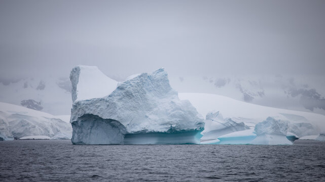 Irregular Sculpted Iceberg, Mountain Backdrop