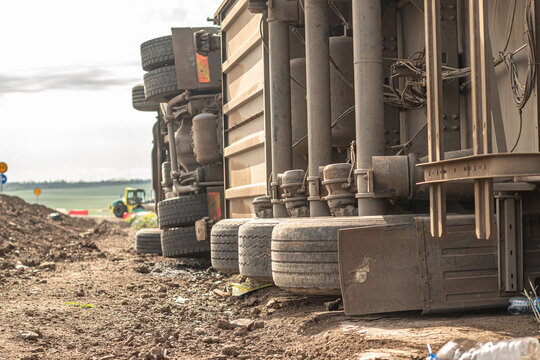 The large truck lies in a side ditch after the road accident. Close-up image