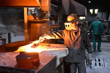 young worker in protective clothing at work at the blast furnace in an iron foundry © industrieblick