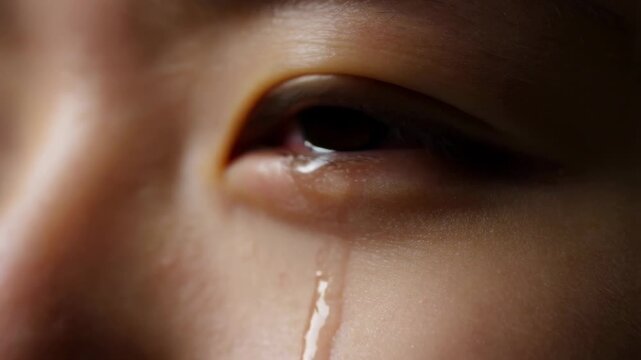 Close-up of a tear rolling down a person's cheek. A poignant moment reflecting deep emotion and vulnerability