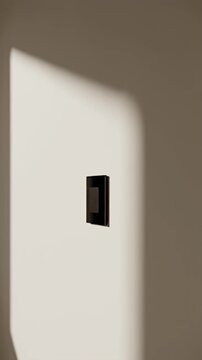 Modern black square light switch on a white wall.