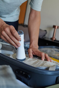 man using a vacuum pump to store clothes in a bag