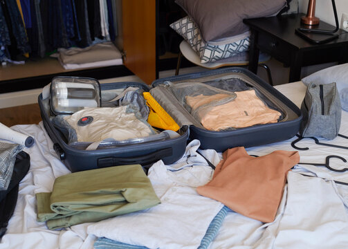 an open suitcase organized with travel clothes