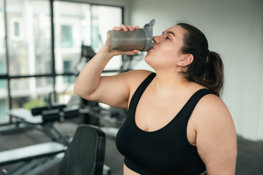Plus Size Woman Drinking Protein Shake After Gym Workout, Healthy Lifestyle and Fitness Journey