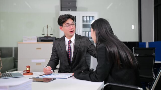 Asian attorney offering support and legal advice to a distressed woman during an office
