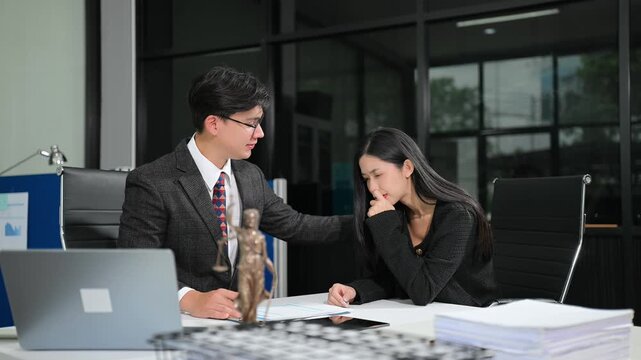 Asian attorney offering support and legal advice to a distressed woman during an office