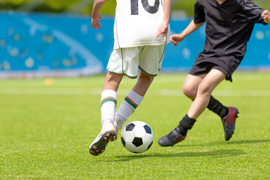 Football Soccer Action Shot: Close-Up of Players Dribbling and Defending Ball on Green Pitch