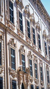 Classic Limestone Facade with Green Wooden Shutters in Valletta