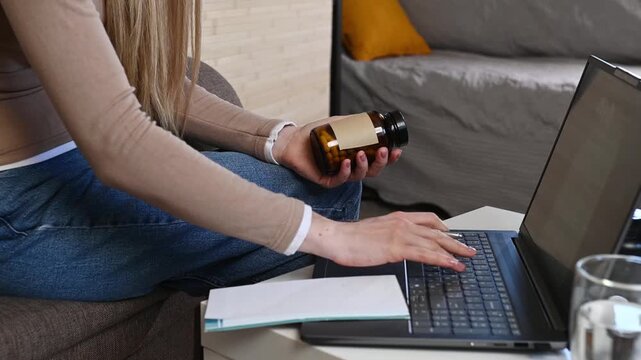 A blonde with long hair unpacks a package and reads the instructions on the label of a hair and skin growth capsule. Dietary supplements