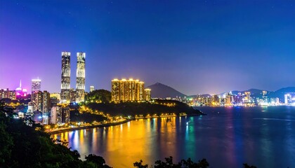 Naklejka premium Vibrant Hong Kong cityscape at night showcasing illuminated modern skyscrapers reflecting in the tranquil bay water under a deep blue evening sky