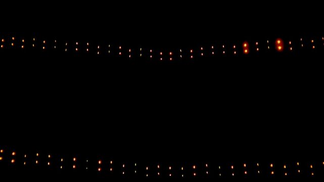 Rows of glowing orange string lights hanging in the dark night with smoke or fog