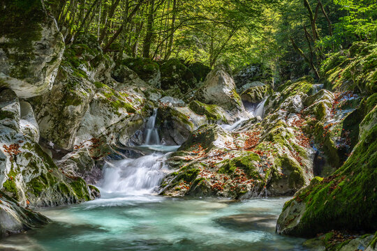Clear waters flow gently over mossy rocks in Sunik, lepena Valley,, Slovenia, creating a peaceful natural retreat ideal for travelers seeking tranquility.