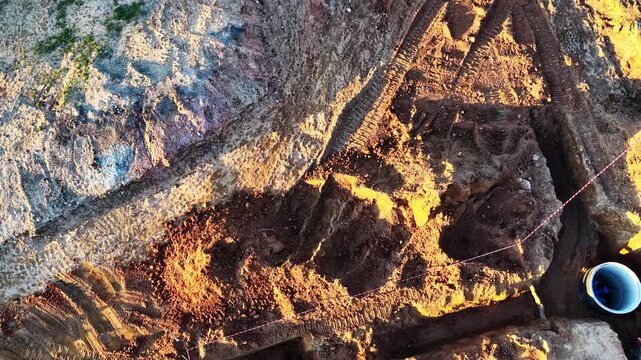 Aerial view of an excavation site revealing road construction site and trenches