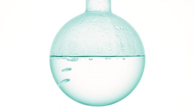 Bubbles moving upward through crystal-like liquid gently boiling in round-bottom flask, condensing on walls on solid white surface | Cyclomethicone cosmetic substance concept
