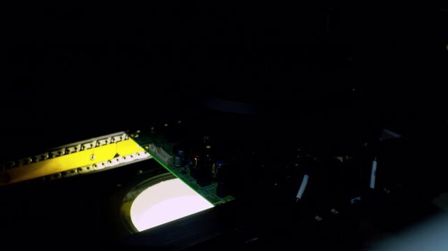Modern electronics manufacturing line with a PCB moving under stroboscopic flashes.Automated optical inspection closeup shot