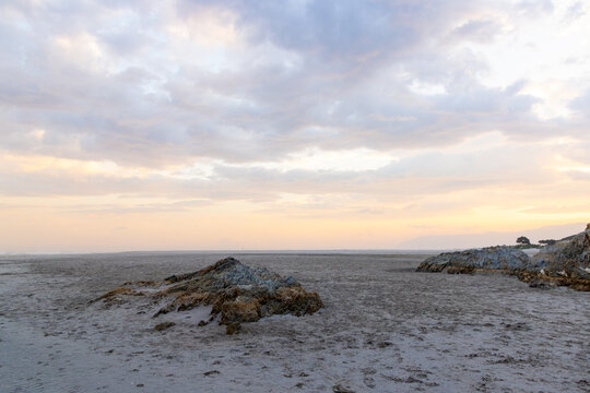 low tide at rocky coastline of Grotto Beach, Hermanus, South Africa at dusk
