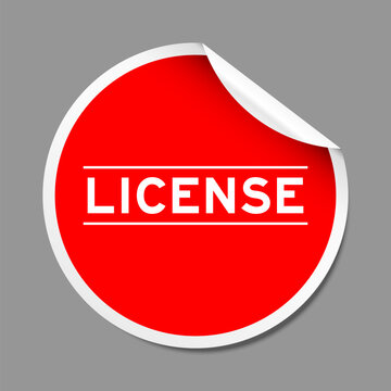 Red color peel sticker label with word license on gray background
