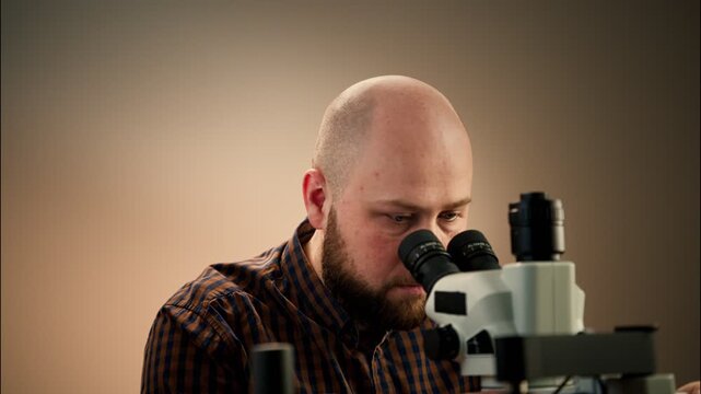 Electronics Technician Inspecting Components Under Stereo Microscope