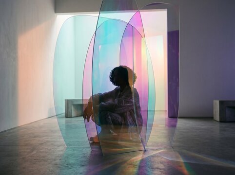 Person Meditating Inside Colorful Glass Installation