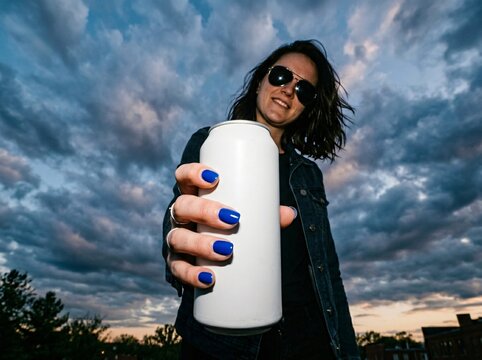 Woman holding white can outdoors sunset sky