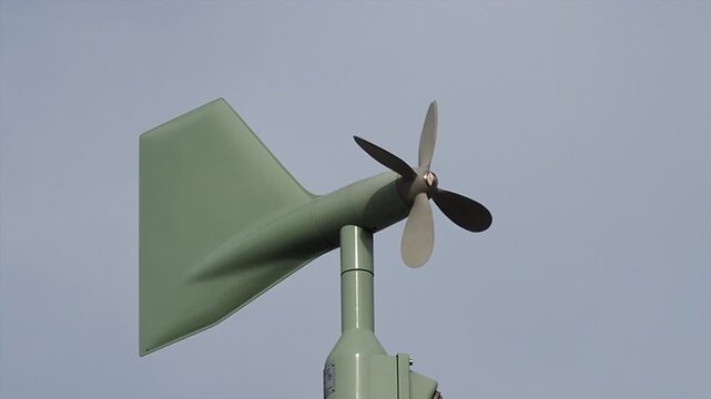 風に反応して回る小型風力発電機の屋外シーン