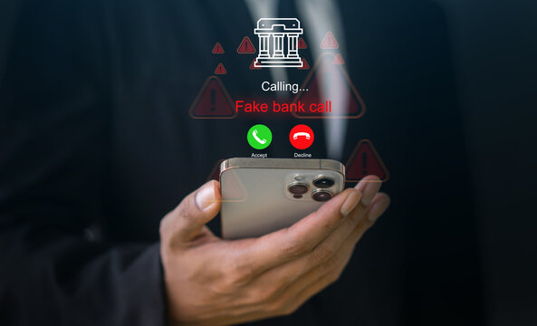 Businessman holding smartphone with fake bank call graphic interface, Financial fraud, cybercrime, scammer caller, phishing warning, online security threat, telecommunication danger and protection
