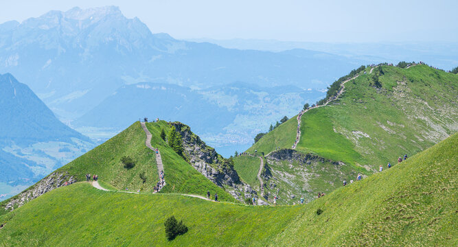 People hiking on stoos gratweg mountain ridge path in switzerland