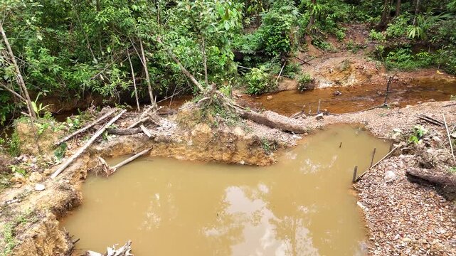 Drone footage showing eroded soil,excavation remains and tropical vegetation at a former gold mining site near Cacao, French Guiana.