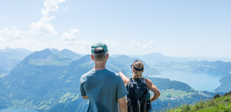 Couple hiking gratweg stoos path admiring swiss alpine panorama