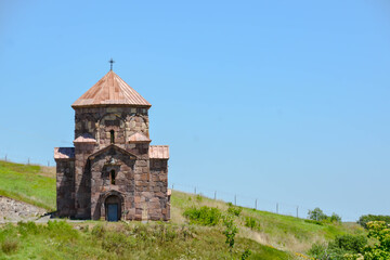 Fototapeta premium The cross of jesus christ on the church. Armenian apostolic church in nature. Monastery complex in the forest