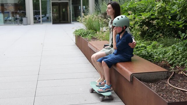 Mother and a son enjoying outdoor rollerblading in a modern urban garden setting