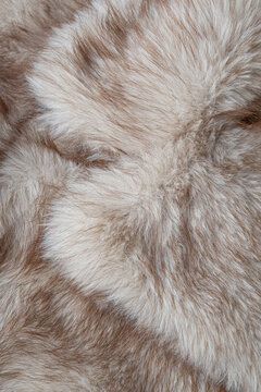 Close up view of a soft luxurious fluffy beige and brown synthetic fur textile background