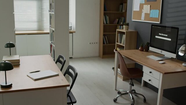 Empty classroom desks standing in modern library with computer monitor showing web browser. Clip serves well for educational marketing, online learning promos, and school enrollment campaigns