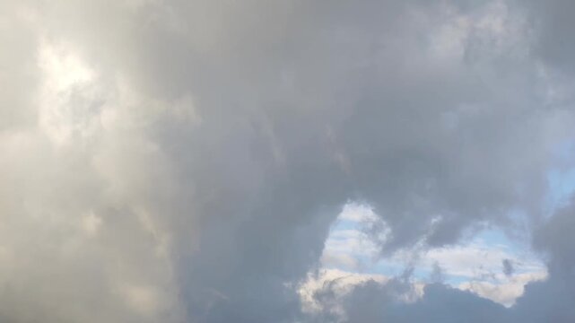 Golden and dark stratocumulus clouds moving in the sky at sunrise