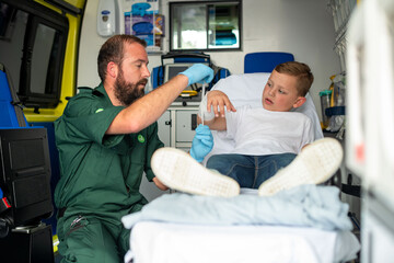 Paramedic assisting a young boy in an ambulance setting. © Rawpixel.com