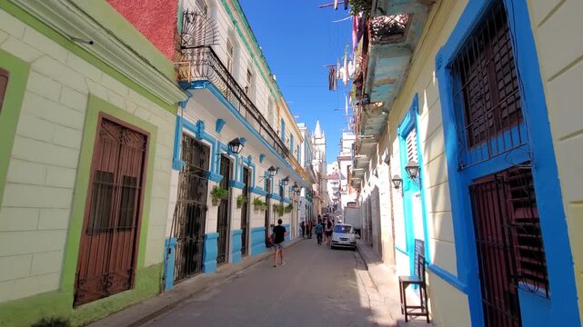 La Habana, Cuba - 21 June 2026: View of Obispo street featuring colorful colonial buildings, balconies, and pedestrians walking along the narrow historic thoroughfare.