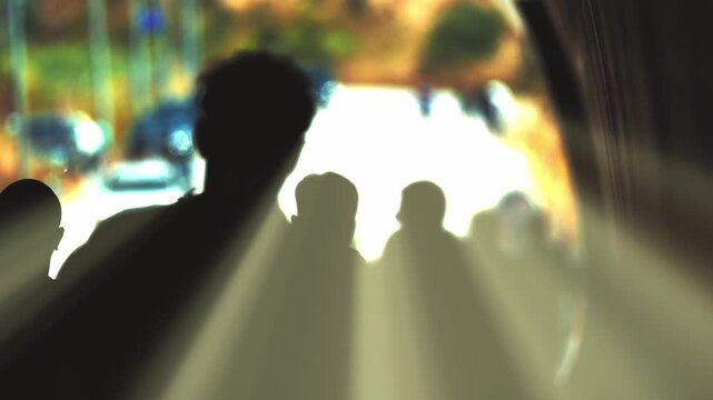 Crowd silhouette of people walking into the light
