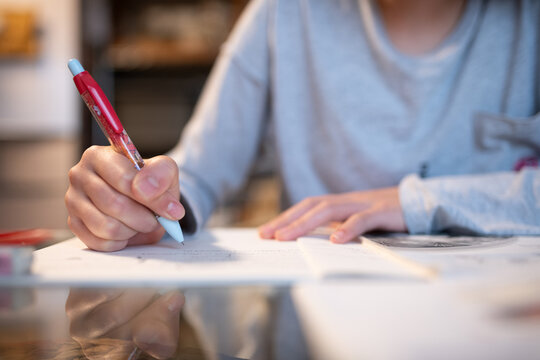 室内で集中してノートにペンで文字を書く中学生の手元 - 勉強・学習
