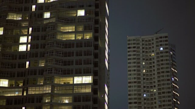 Jakarta residential/mixed towers close-up, lit windows at night