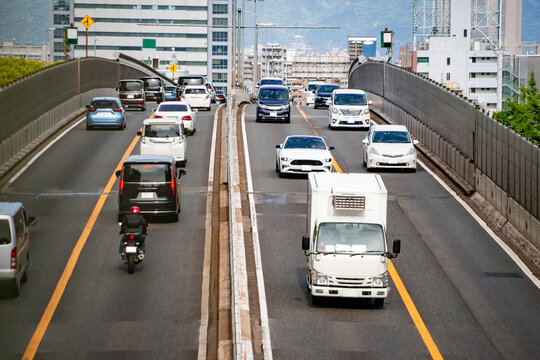 阪神高速の跨道橋を行き交う多くの自動車とトラック