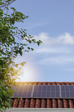 Solar Panel Array on Residential Roof with Sun Flare