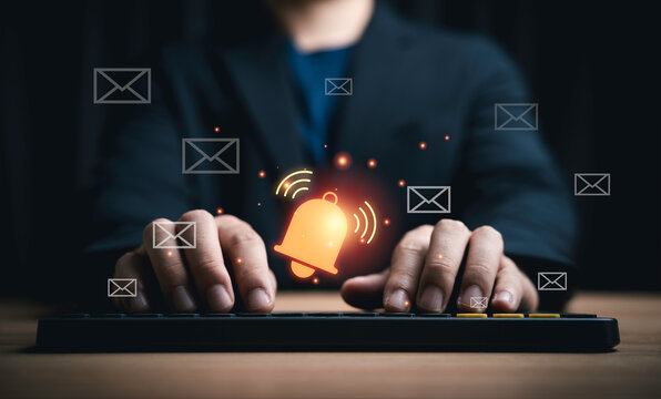Businessman using keyboard with email notification alert icons and digital messaging symbols for email marketing, communication technology, online notification, customer engagement management concept.