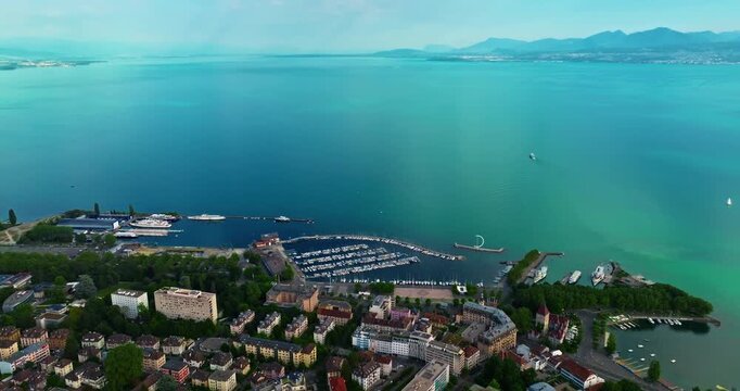 Establishing shot of swiss city Lausanne in summer day. Aerial view of the Switzerland city on the shores of Lake Geneva