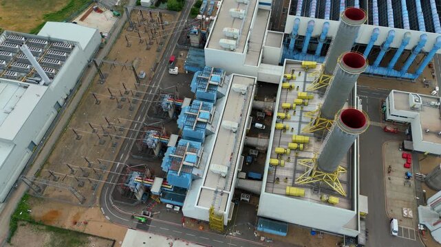 Top down aerial view of massive power station chimney stacks and industrial infrastructure in Hoddesdon, UK