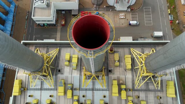 Top down aerial view of massive power station chimney stacks and industrial infrastructure in Hoddesdon, UK