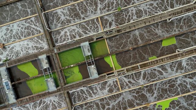 Top-down aerial view of active aeration lanes with bubbling activated sludge at a wastewater treatment works