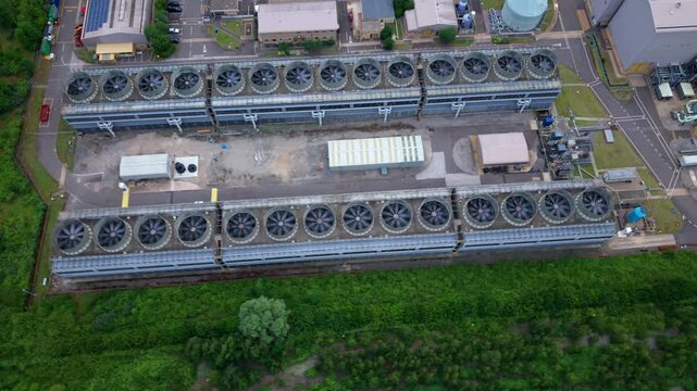 Aerial view of a large energy production power plant with rows of rotating turbines visible on the generation house roof in Bedfordshire, UK.