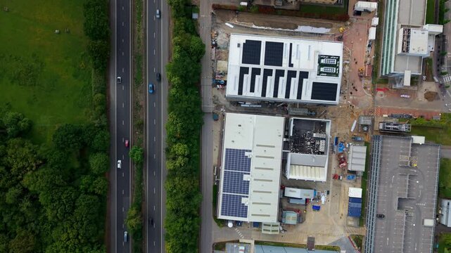 Top-Down Aerial View of A1 Road Traffic and Industrial Factory Roofs with Solar Panels